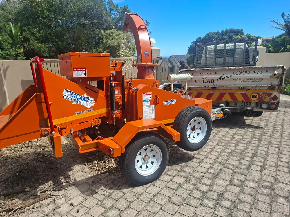 Mobile wood chipper turning branches into mulch on site